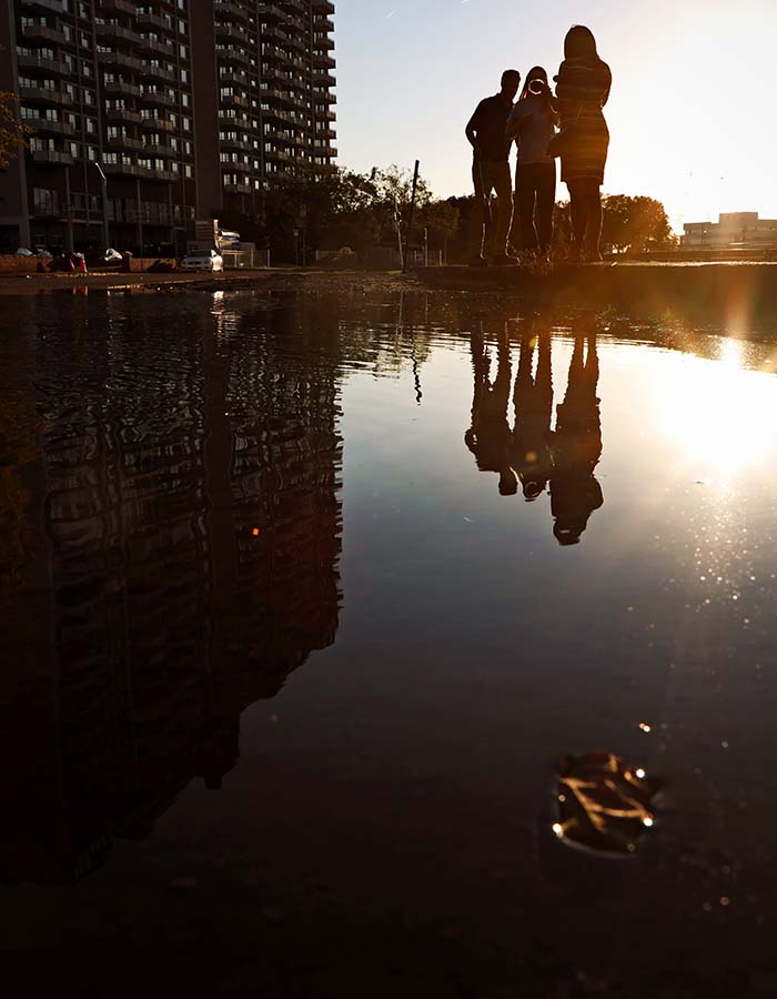 Image of university students measuring flooding on a city street.